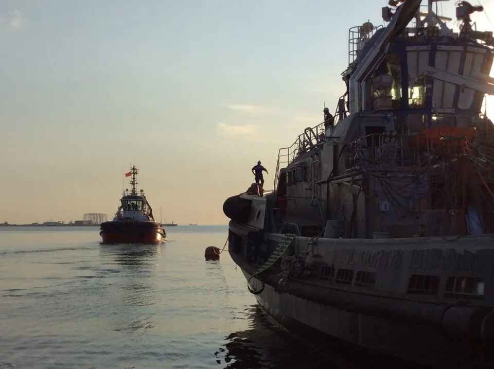 Tug and vessel at sunset