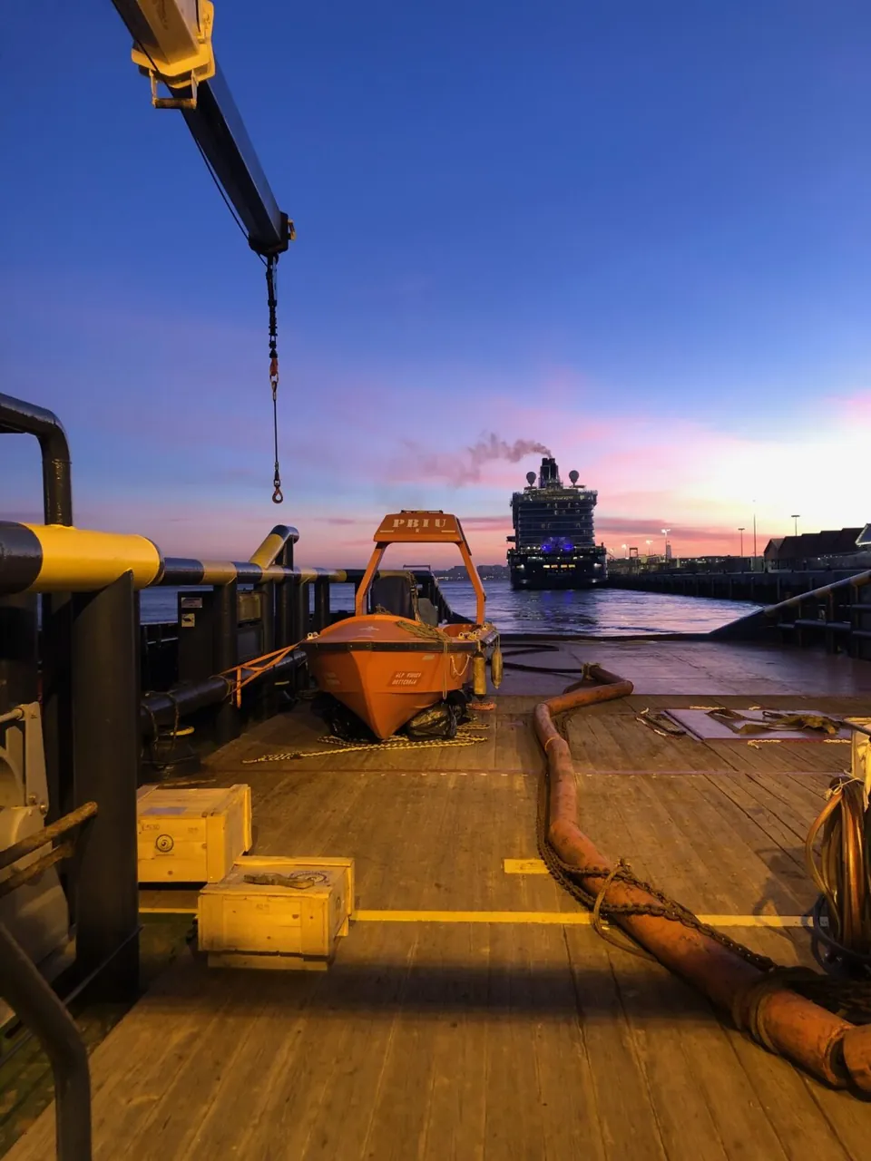 Tug deck at dusk with a cruise ship in the distance