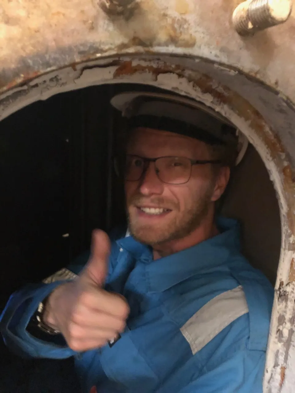 Bert Timmers inside a tank hatch, thumbs up